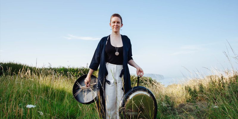 Aleisha with drums and a gong on the dunes